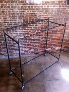 a metal frame sitting on top of a floor next to a brick wall