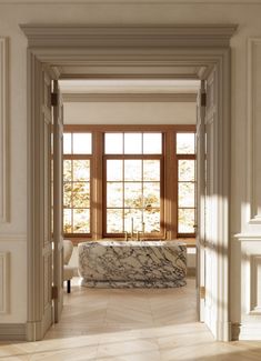 an open door leading to a bathroom with marble tub