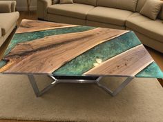 a coffee table made out of wood and glass in the middle of a living room