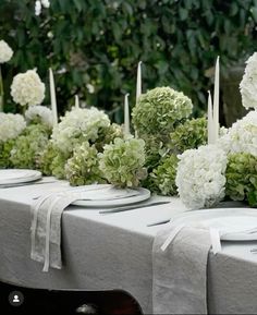 the table is set with white flowers and candles