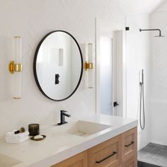 a bathroom with two sinks and a large mirror above the sink, along with a walk in shower