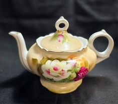 This vintage Lefton musical teapot is a beautiful addition to any collection. Made in Japan, it features a lovely rose chintz design with gold trim. The teapot is perfect for serving tea or as a decorative piece. It is not handmade and comes from a trusted brand. This item is a must-have for collectors of music boxes and decorative collectibles. Floral Teapot, Music Boxes, Music Box, Made In Japan, Decorative Pieces, Musical, Trim