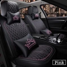 the interior of a car with black leather and pink stitching, crown - shaped pillows