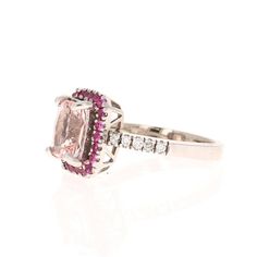 A lovely Engagement Ring Option or as an alternate to a Pink Diamond Ring!   This gorgeous and classy Morganite and Diamond Ring has a 1.88 Carat Emerald Cut Pink Morganite and is surrounded by a simple halo of 22 Pink Sapphires that weigh 0.36 Carats and 10 Round Cut Diamonds along the shank of the ring that weigh 0.15 carats (Clarity: SI2, Color: F).  The total carat weight of the ring is 2.39 Carats.  It is set in 14K White Gold and weighs approximately 4.8 grams.   The ring is a size 7 and can be resized at no additional charge. Classic Pink Cluster Ring For Formal Occasions, Pink Halo Ring With Prong Setting For Formal Occasions, Formal Pink Halo Ring With Prong Setting, Classic Pink Ruby Ring With Halo Setting, Pink Platinum Ring With Center Stone, Classic Pink Halo Ring, Platinum Pink Rings With Halo Setting, Formal Pink Rings With Halo Setting, Elegant Pink Platinum Rings