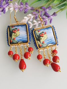 Pendant earrings with glazed lava stone tiles with handmade Caltagirone motifs, with white and blue bead frame, 2 x 2 cm in size, imitation red coral paste pearls, anallergic brass nuns closure. Length 8 cm. Red Bohemian Rectangular Earrings, Bohemian Red Rectangular Earrings, Handmade Mediterranean Jewelry For Gift, Tile Earrings, Bead Frame, Ceramic Earrings, White Pearl Earring, Ceramic Earring, Earrings Red