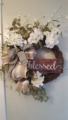 a wreath with flowers and ribbon hanging on the wall next to a sign that says released