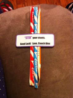 a cross made out of toothbrushes sitting on top of a chair with a sign that says, stix your stunts good luck love coach alex