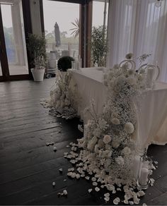 the table is covered with white flowers and candles for an elegant touch to the room