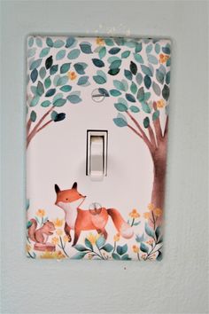 a light switch cover with an image of a fox and tree painted on the wall