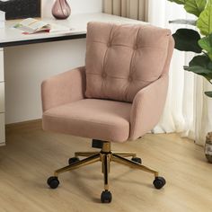 a pink office chair sitting on top of a wooden floor next to a white desk