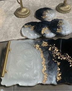 two black and white plates sitting on top of a table next to a gold pen