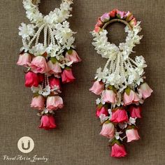 two pink and white flowers are attached to earrings