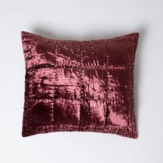 a red velvet pillow on a white background