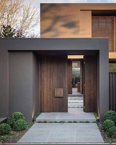 an entrance to a modern home with wood and metal sidings on the outside wall