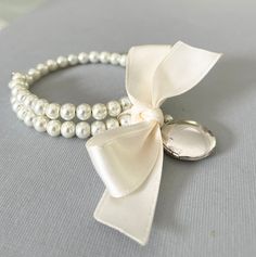 Hand made by Pearly Jane Bridal (me!) just for you when you place an order! I take great care making your order. Please allow two weeks for meticulous construction of your jewelry. If you need your order sooner be sure to let me know! High quality glass pearls Silver locket  Perfect for bridesmaids giftsk one size fits all This bracelet is lovely! Pearls are strung on memory wire and finished with a keepsake locket and an ivory bow. No worries about fitting all your bridesmaids wrists! If more than 1 bracelet is ordered gift boxes are included. Silver Locket, Wedding Party Jewelry, Etsy Bridesmaid Gifts, Wedding Jewelry Bracelets, Silver Lockets, Memory Wire, Party Jewelry, Gifts For Wedding Party, Wedding Bracelet