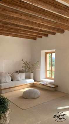 a living room filled with furniture and a large white pillow on top of a rug