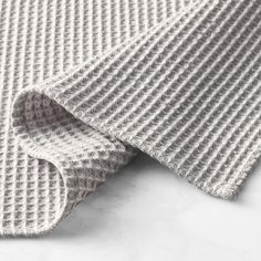 a close up view of the grey and white knitted fabric on top of a table