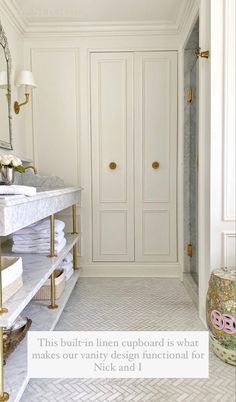 a bathroom with white cabinets and marble counter tops