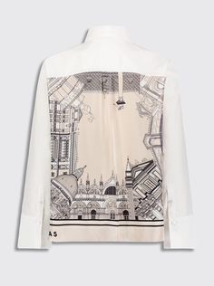 a white shirt with a black and white drawing on the front, long sleeves and cuffs