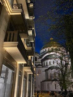 the building has many balconies and lights on it's sides at night