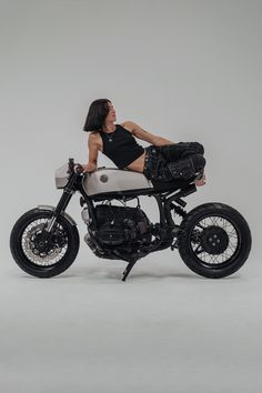 a woman sitting on top of a motorcycle with her legs spread out in the air