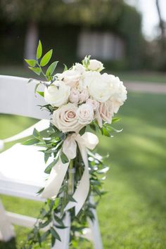 a bouquet of flowers sitting on top of a white chair in the middle of a field