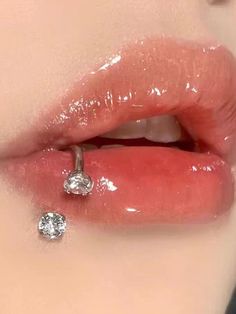 a woman's lips and nose are covered in clear liquid with diamond studs