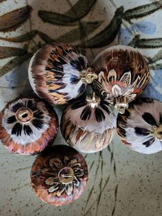 four decorative vases sitting on top of a table