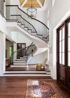 a staircase in a home with wood floors and white walls, along with a rug on the floor