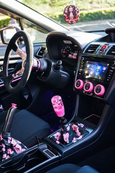 the interior of a car with pink and black flowers on its dash board, steering wheel, and dashboard