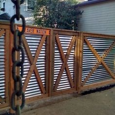 a wooden fence with a sign on it that says layer main and is attached to a chain link fence