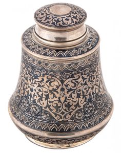 an ornately decorated metal container with a lid on it's side, isolated against a white background