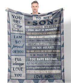 a man holding up a blanket with words on it