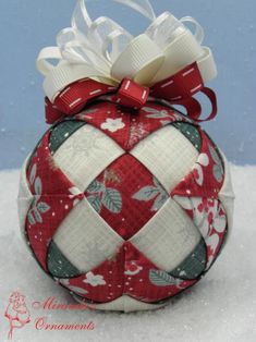 a red and white ornament with a bow on it