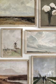 many paintings are hanging on the wall in front of each other, including windmills and flowers