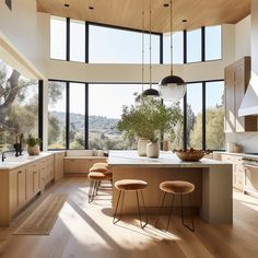 a kitchen with wooden floors and large windows overlooking the mountains is pictured in this image