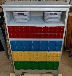 a multicolored cabinet with two baskets on top and three bins on the bottom