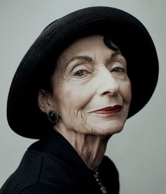 an older woman wearing a black hat and looking off to the side with her eyes wide open