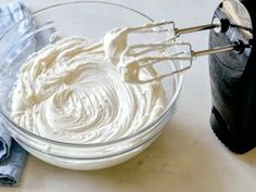 a bowl filled with whipped cream next to a blender