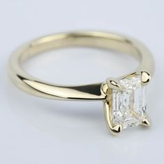 an engagement ring with a princess cut diamond in the center, on a white background