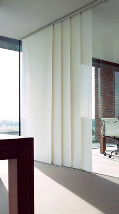 an empty room with sliding glass doors and a table in the foreground, outside