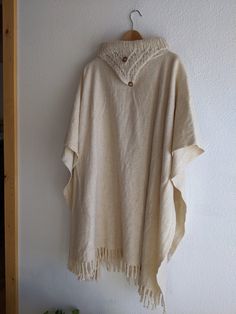 Amazing Wool poncho, cape, in woven cream wool with handknit collar detail. Real wood buttons are sewn on, but not functional. I believe that this was made by hand privately, not by a brand. Plenty of fabric to keep cozy, but with lovely drape and movement. While this is undoubtedly vintage, it also feels really relevant and versatile. The natural cream color looks amazing with denim and brown leather. Could look super chic belted! Sizing is very open, but I am happy to provide measurements for Handmade Beige Poncho One Size, Beige Wool Poncho One Size, One Size Beige Wool Poncho, Cozy Beige Wool Poncho, Traditional Beige Poncho For Winter, Wool Poncho, Wood Buttons, Natural Cream, Poncho Cape