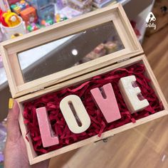 someone is holding a box with letters that spell out love