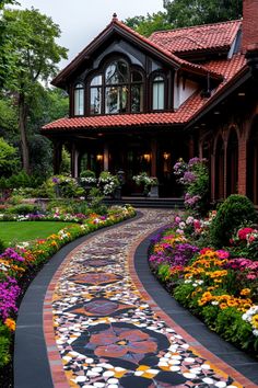 a house that is surrounded by lots of flowers and plants in front of the walkway