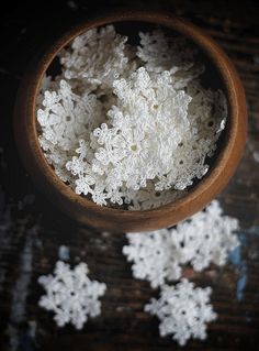 a bowl filled with white rice on top of a wooden table covered in snow flakes