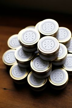 a pile of gold and white tins sitting on top of a wooden table