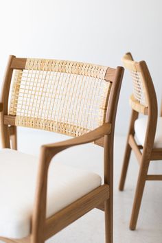 two wooden chairs sitting next to each other on top of a white carpeted floor