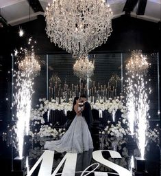 a bride and groom standing in front of a chandelier with the number twenty two