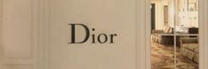 the entrance to a hotel room with a dior sign on it's wall