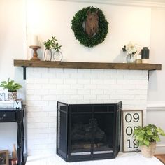 a living room with a fire place and a wreath on the fireplace mantel above it